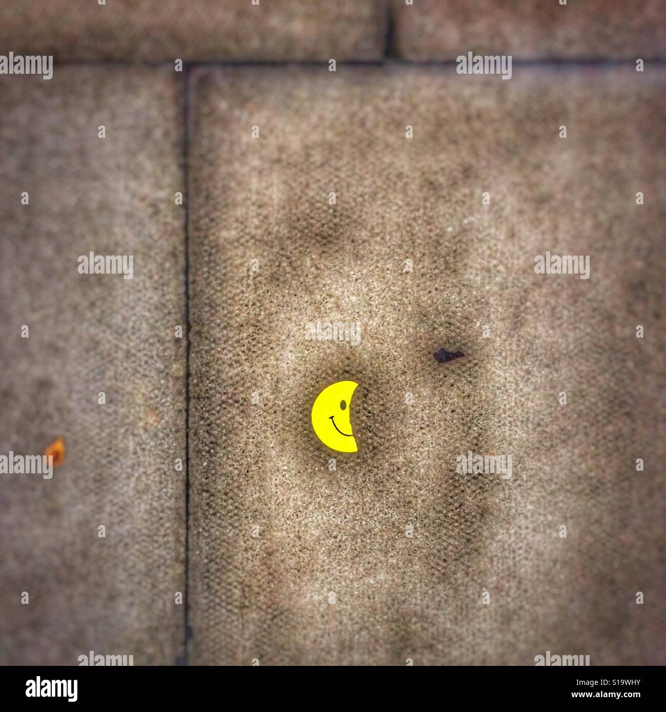 Half a smiley sticker on the pavement - Smartphone Captured Stock Image