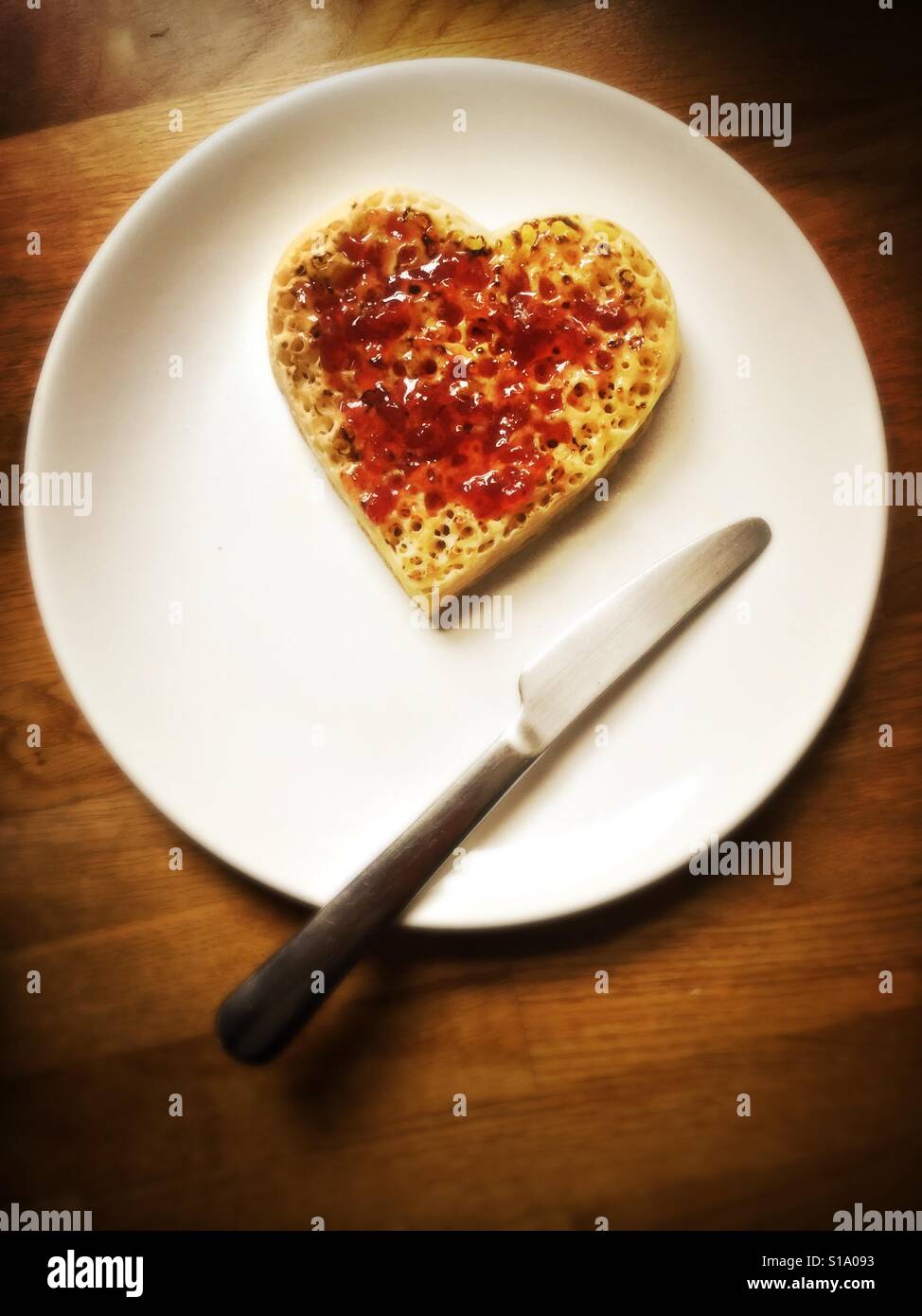 A heart-shaped crumpet covered with strawberry jam during Valentine's Day Stock Photo