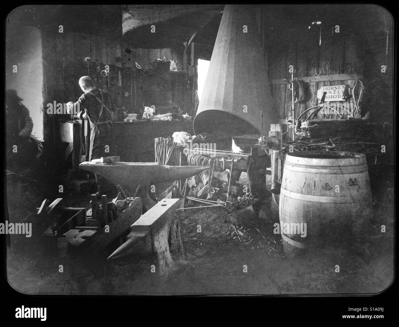 A blacksmith working in his shop on Main Street. Columbia State Historic Park, Columbia, Tuolumne County,  California, USA - Smartphone Captured Stock Image