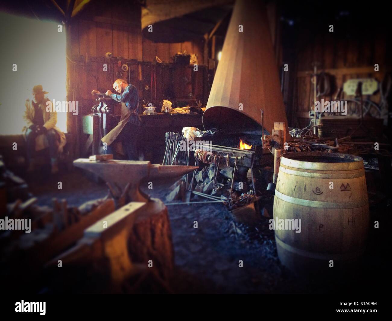 A blacksmith working in his shop on Main Street. Columbia State Historic Park, Columbia, Tuolumne County,  California, USA - Smartphone Captured Stock Image