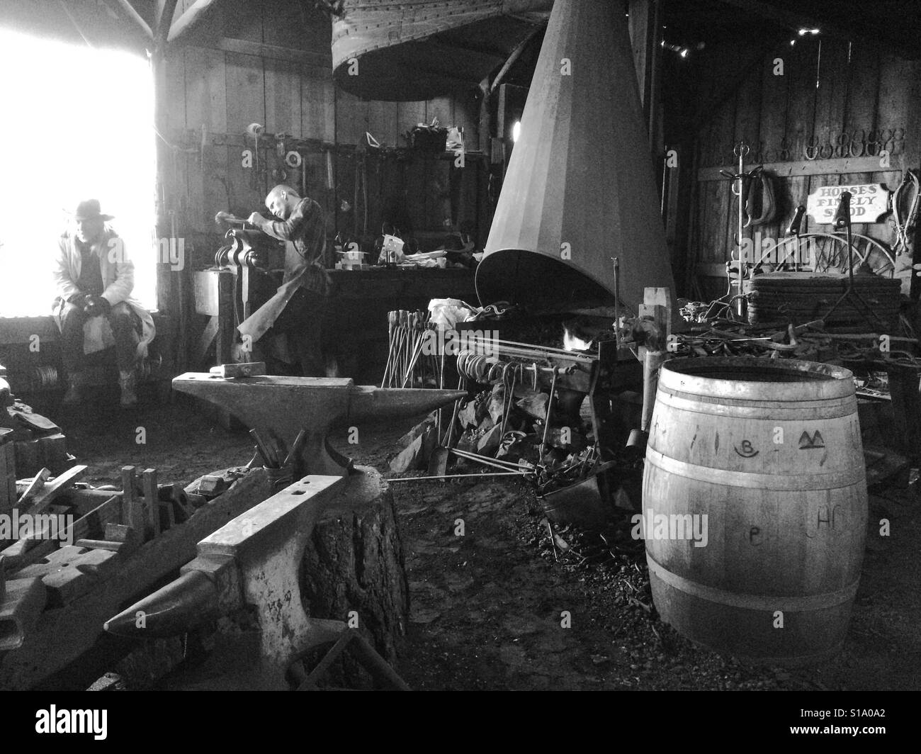 A blacksmith working in his shop on Main Street. Columbia State Historic Park, Columbia, Tuolumne County,  California, USA - Smartphone Captured Stock Image