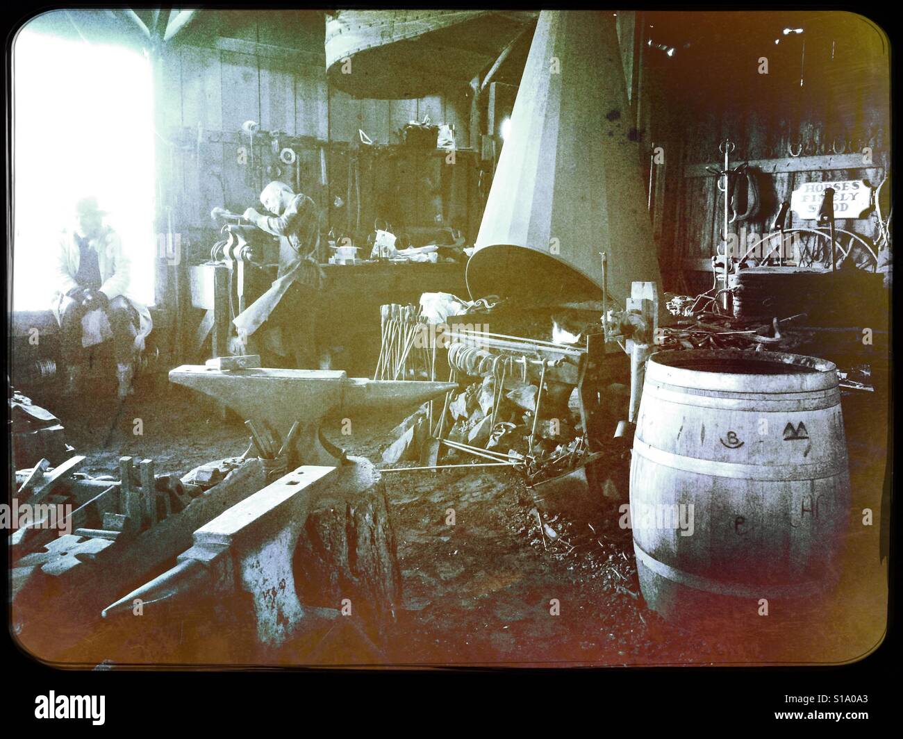 A blacksmith working in his shop on Main Street. Columbia State Historic Park, Columbia, Tuolumne County,  California, USA - Smartphone Captured Stock Image