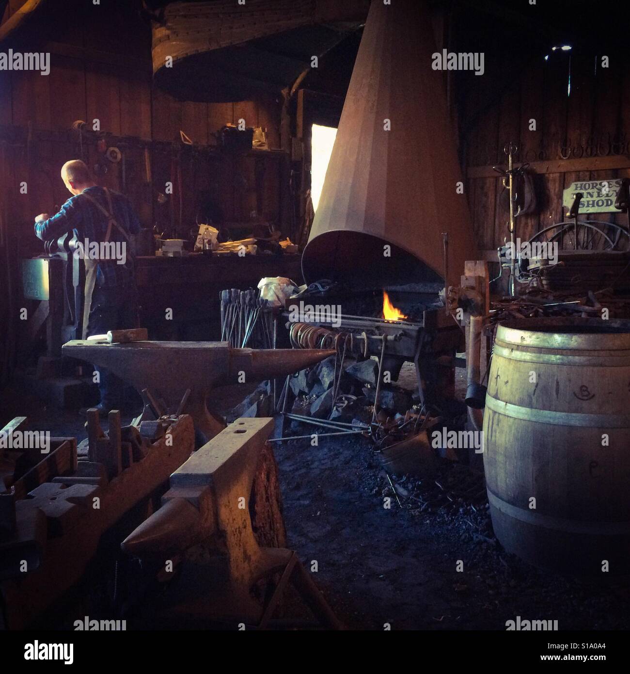 A blacksmith working in his shop on Main Street. Columbia State Historic Park, Columbia, Tuolumne County,  California, USA - Smartphone Captured Stock Image