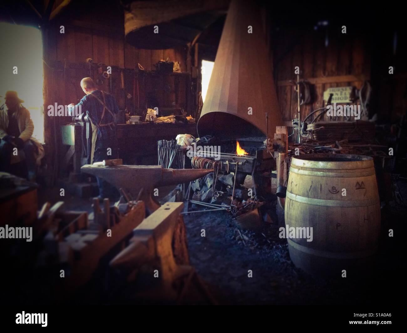 A blacksmith working in his shop on Main Street. Columbia State Historic Park, Columbia, Tuolumne County,  California, USA - Smartphone Captured Stock Image