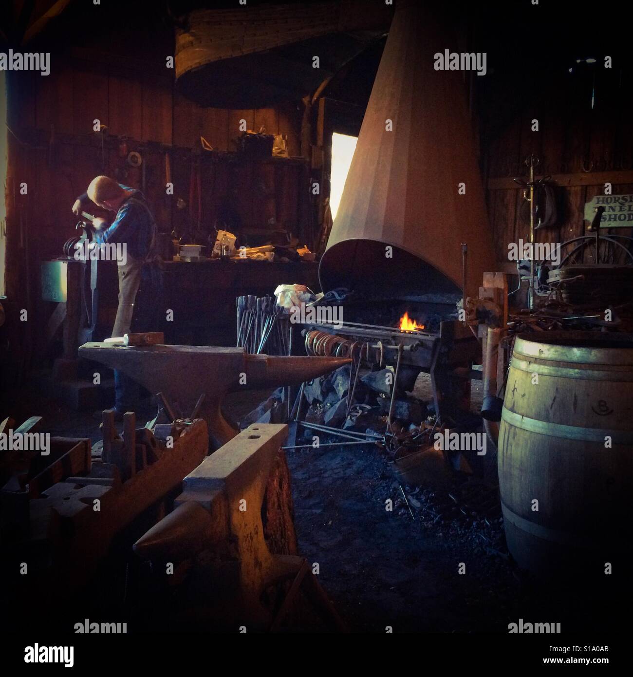 A blacksmith working in his shop on Main Street. Columbia State Historic Park, Columbia, Tuolumne County,  California, USA - Smartphone Captured Stock Image