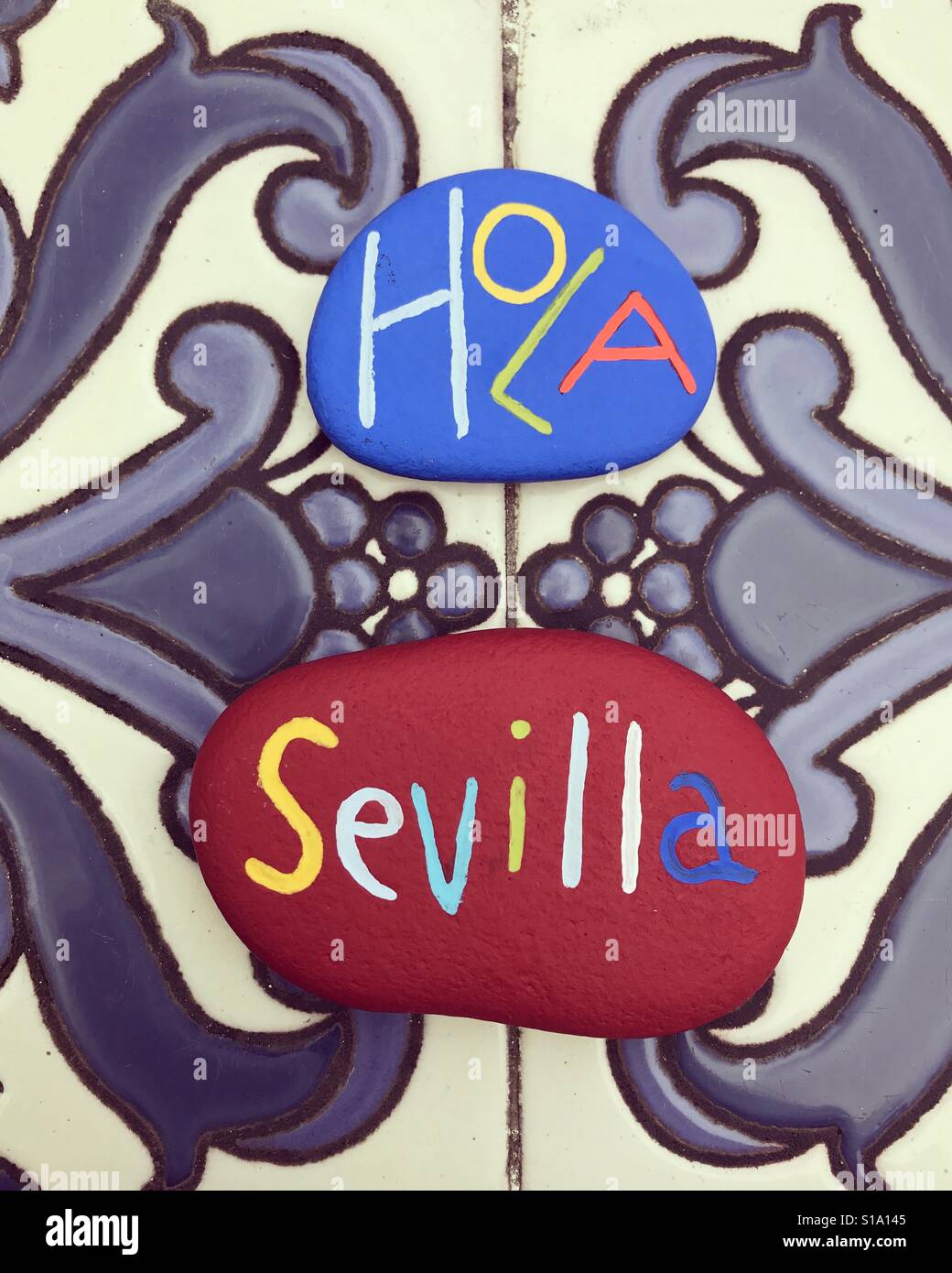 Hola Sevilla, souvenir on colored stones over artistic tiles Stock Photo