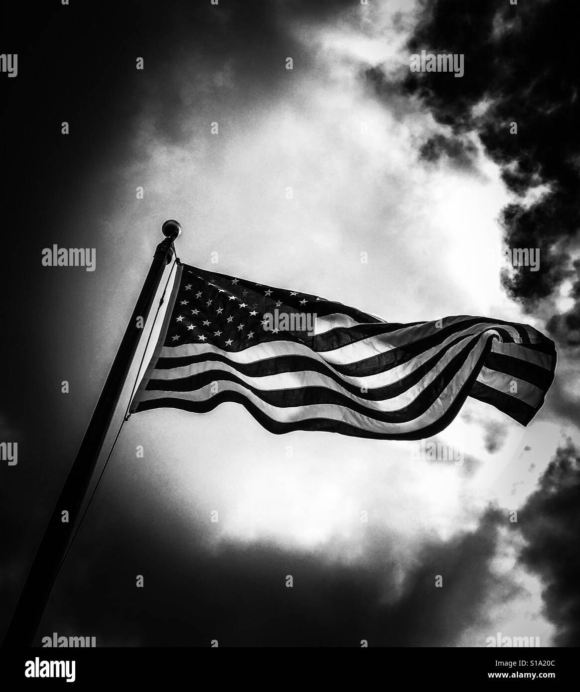 Dramatic edit black and white American flag flying Stock Photo