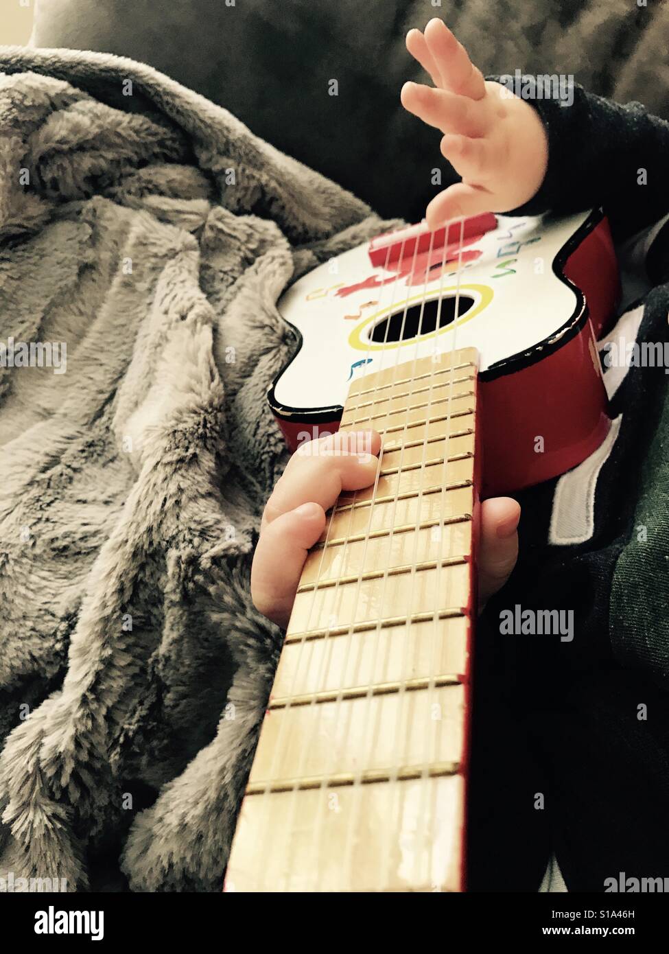 Never too young to learn guitar. Stock Photo