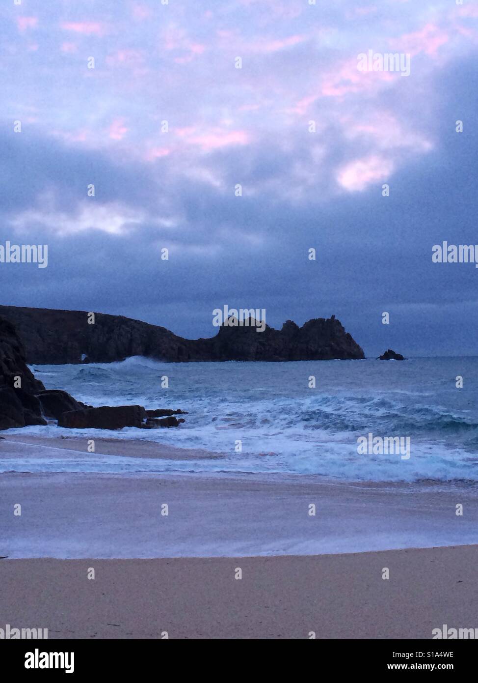 UK weather: sunrise at Porthcurno beach Stock Photo