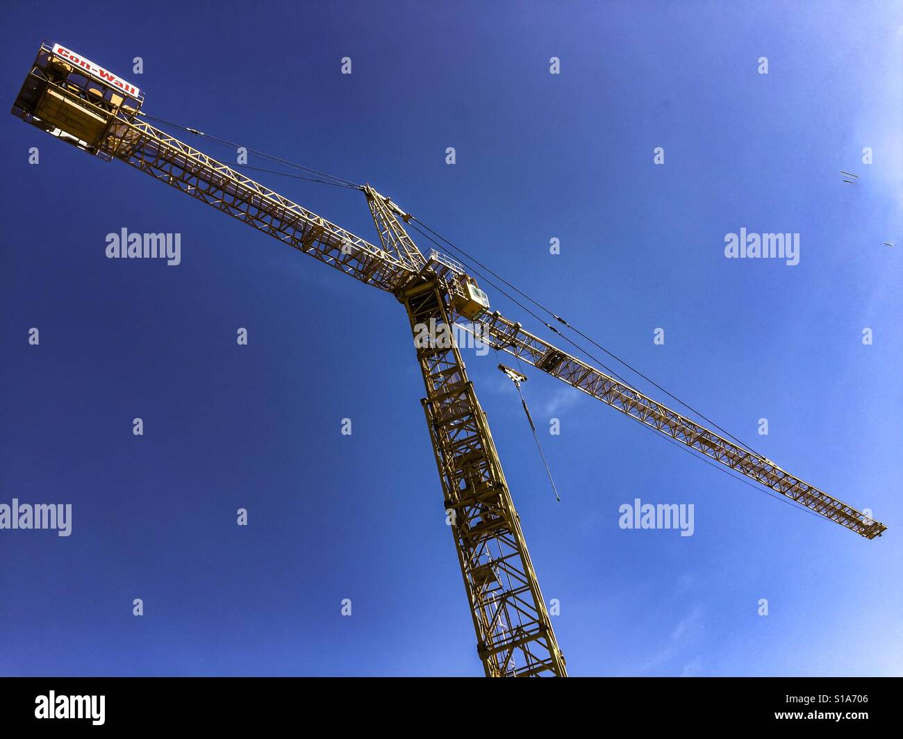 Crane. A very large crane against a clear blue sky at a construction site, Canada. Modern building project. - Smartphone Captured Stock Image