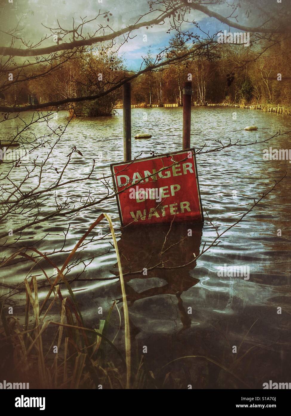 A fallen danger deep water sign on a lake. - Smartphone Captured Stock Image