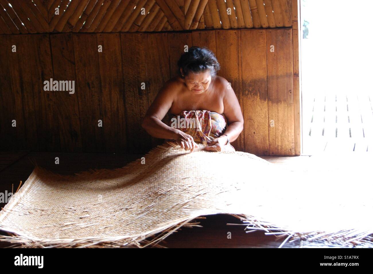 Iban woman mat weaving in the longhouse Batang Ai - Smartphone Captured Stock Image