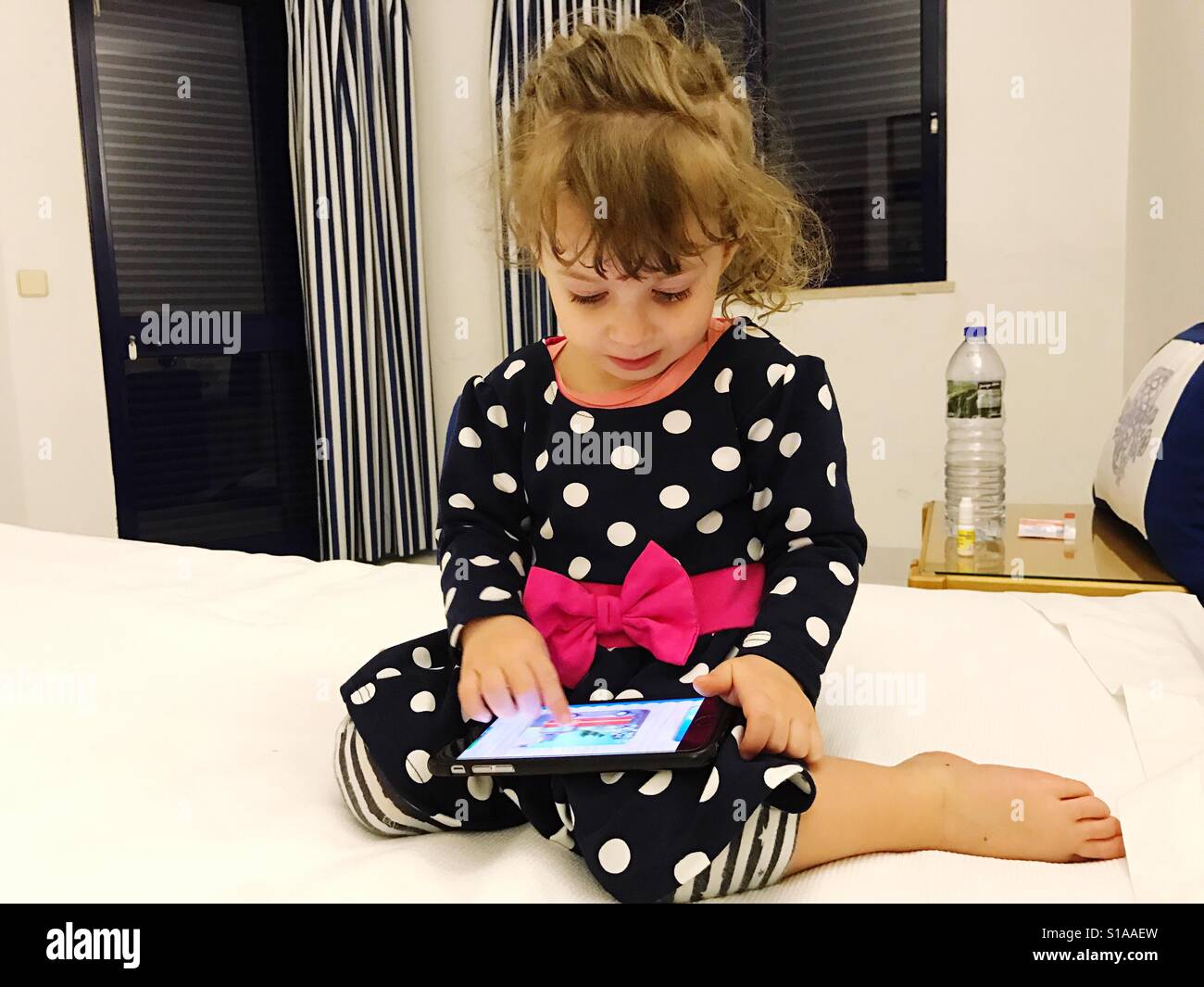 Toddler watching cartoons on a tablet - Smartphone Captured Stock Image