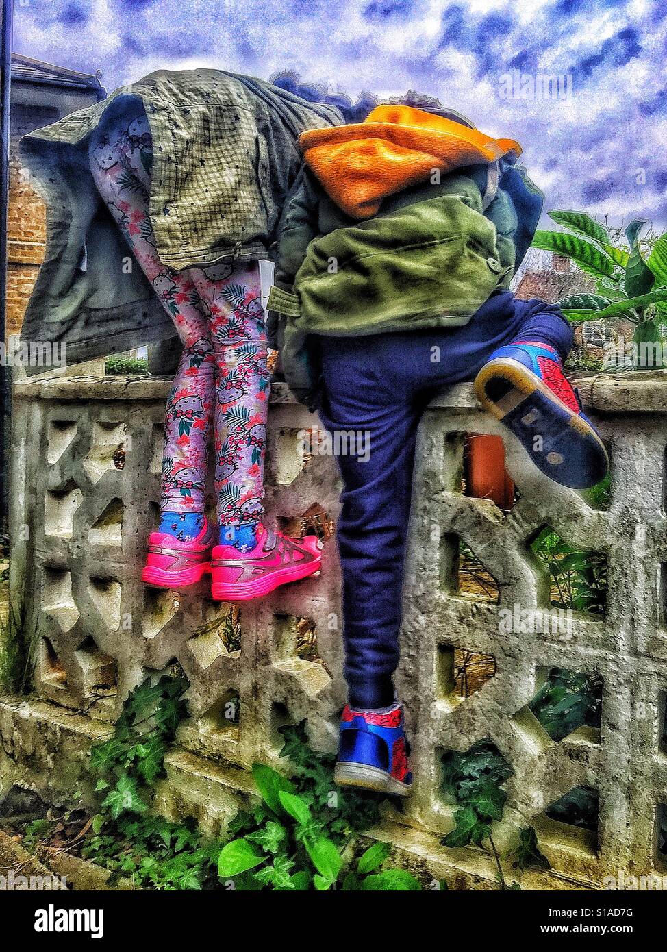 Two children climbing a wall - Smartphone Captured Stock Image