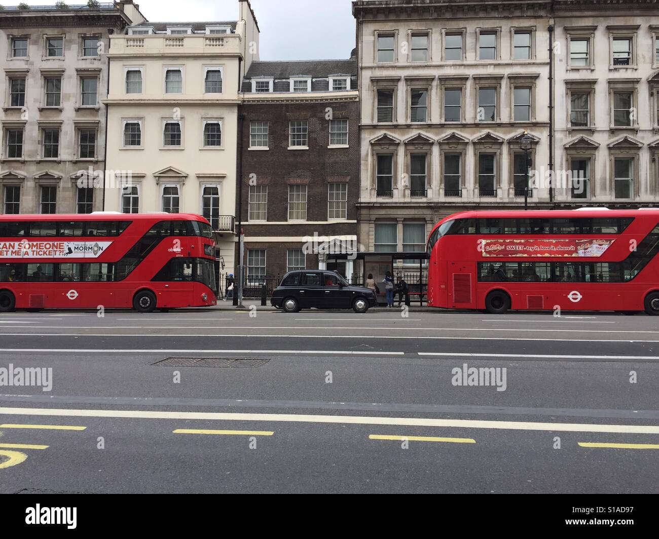 Red buses and a black taxi on Parliament St, Westminster, London, England. Stock Photo