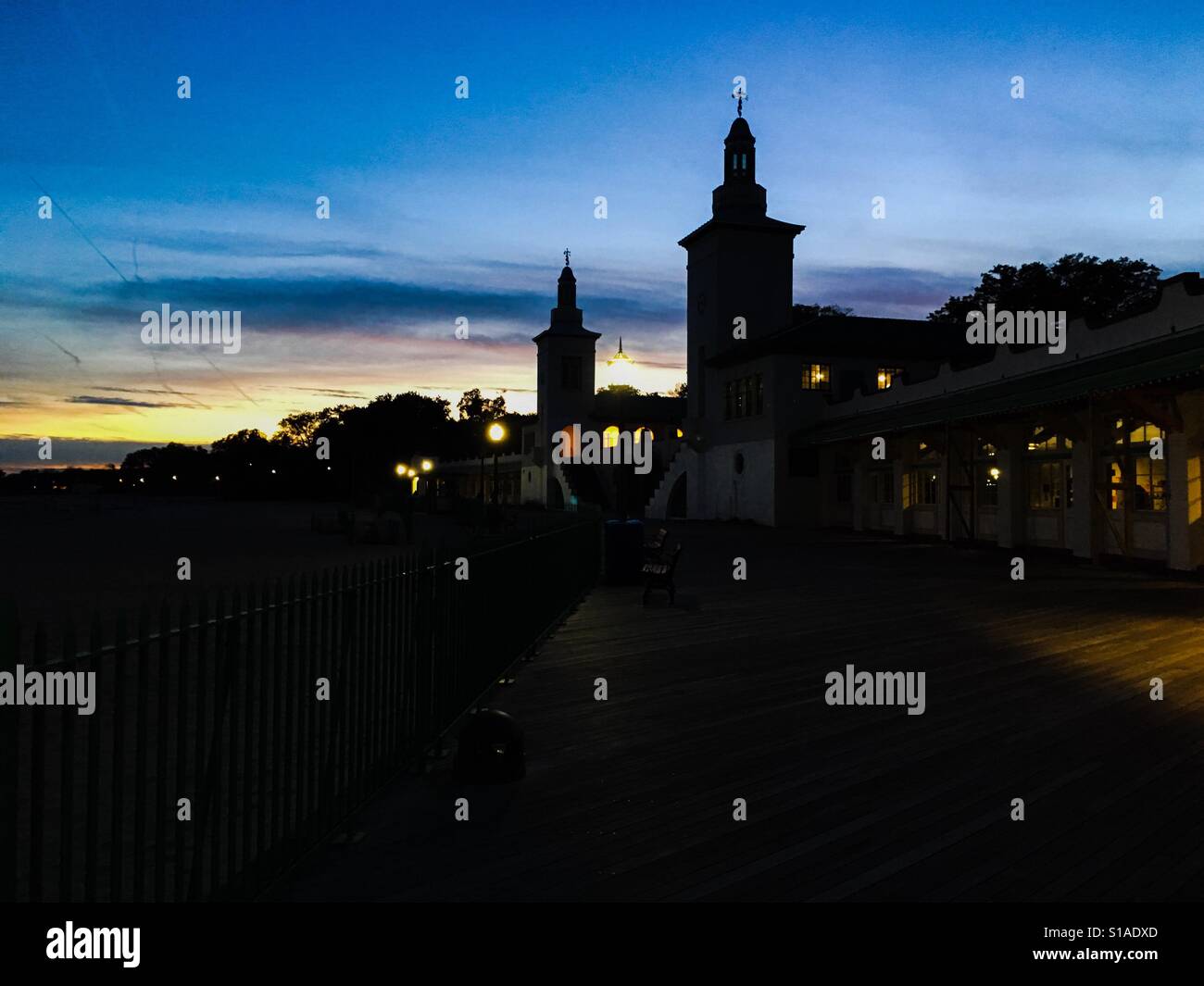 Rye Playland boardwalk beach and buildings in silhouette blue hour after sunset blue and yellow sky in the fall autumn - Smartphone Captured Stock Image
