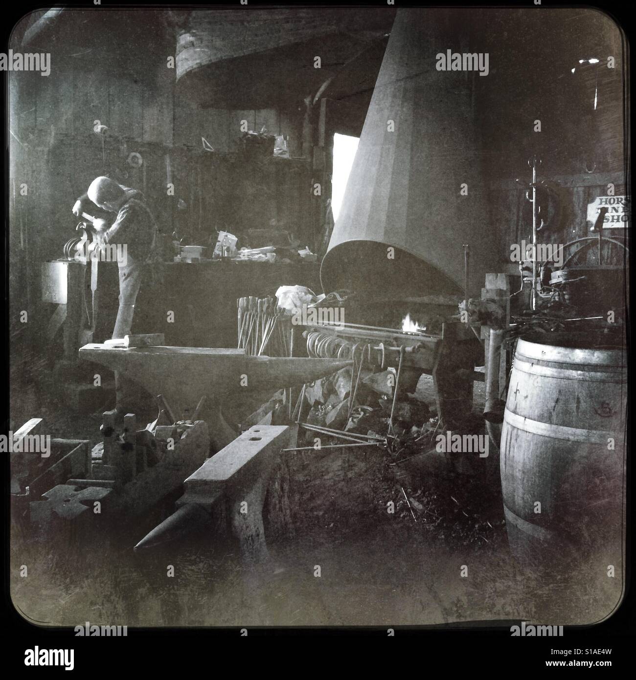 A blacksmith works in his workshop on Main Street. Columbia State Historic Park, Columbia, Tuolumne County,  California, USA - Smartphone Captured Stock Image