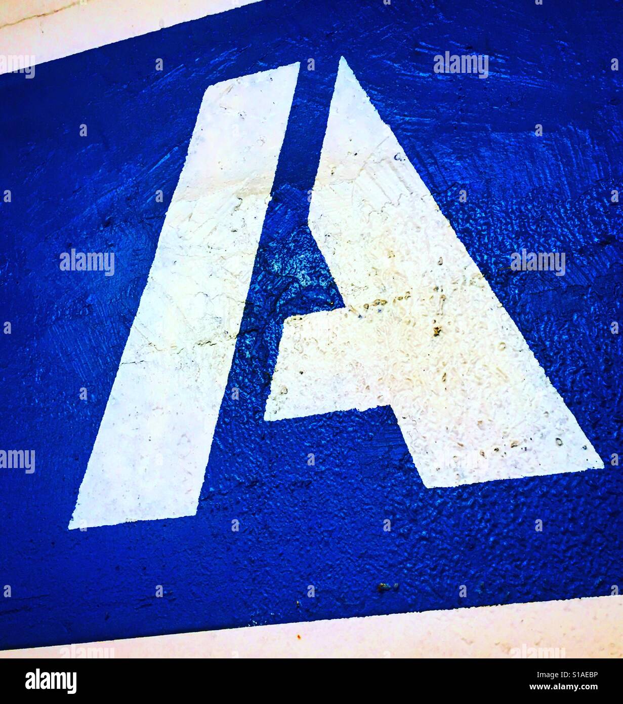 letter A painted in white on blue color - Smartphone Captured Stock Image