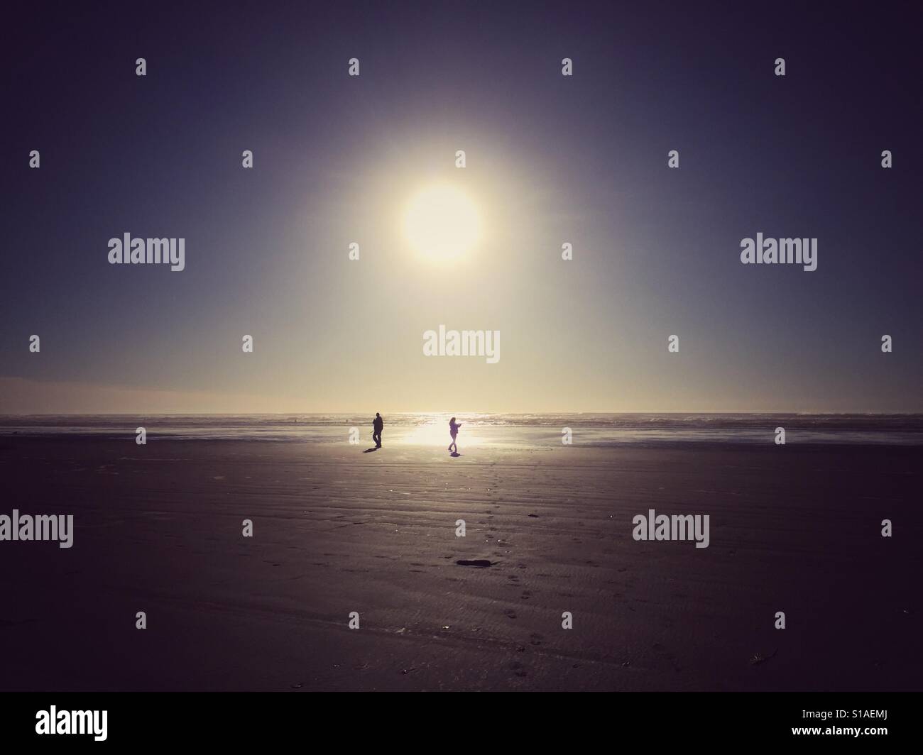Couple enjoys winter sun on the beach on Olympic Peninsula - Smartphone Captured Stock Image
