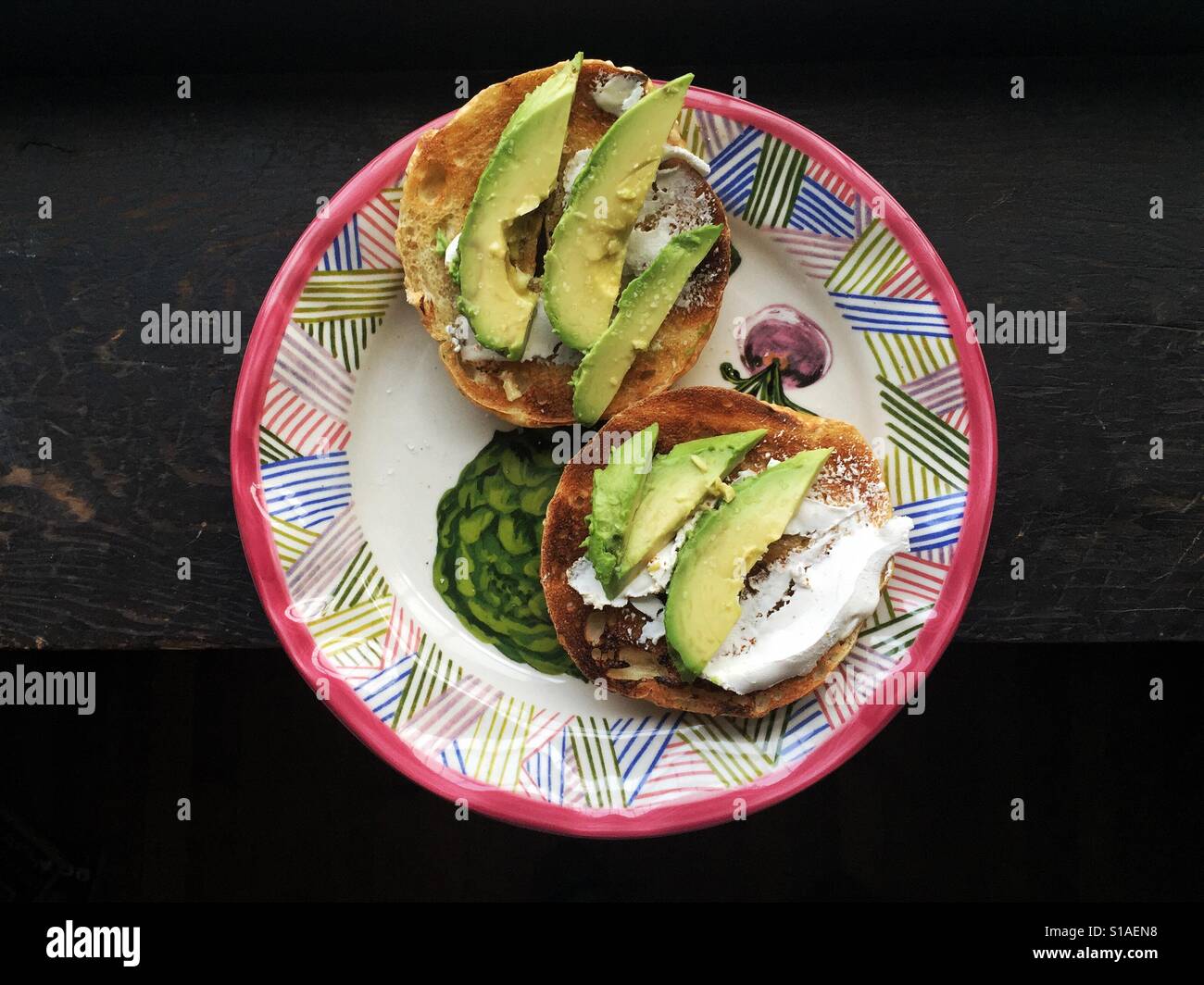 Bagel with avocado on a colorful plate - Smartphone Captured Stock Image