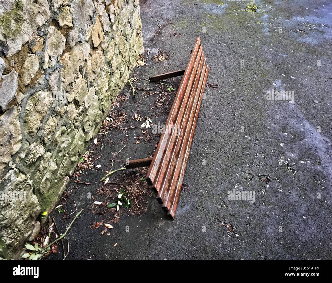 A bench lies on its side after being uprooted from the ground on a street in a town in the UK - Smartphone Captured Stock Image