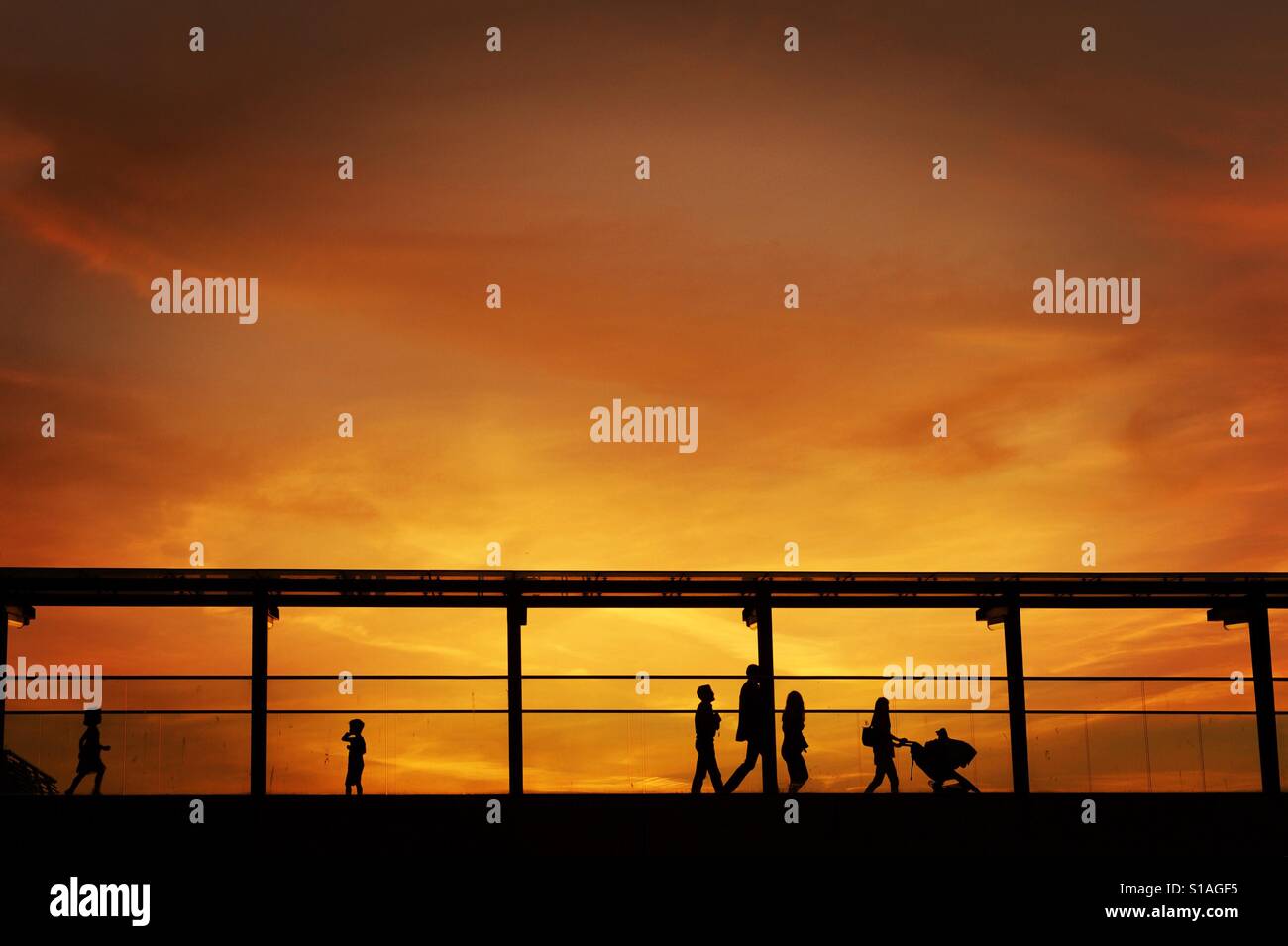 Silhouettes of a family on a bridge at sunset Stock Photo - Alamy