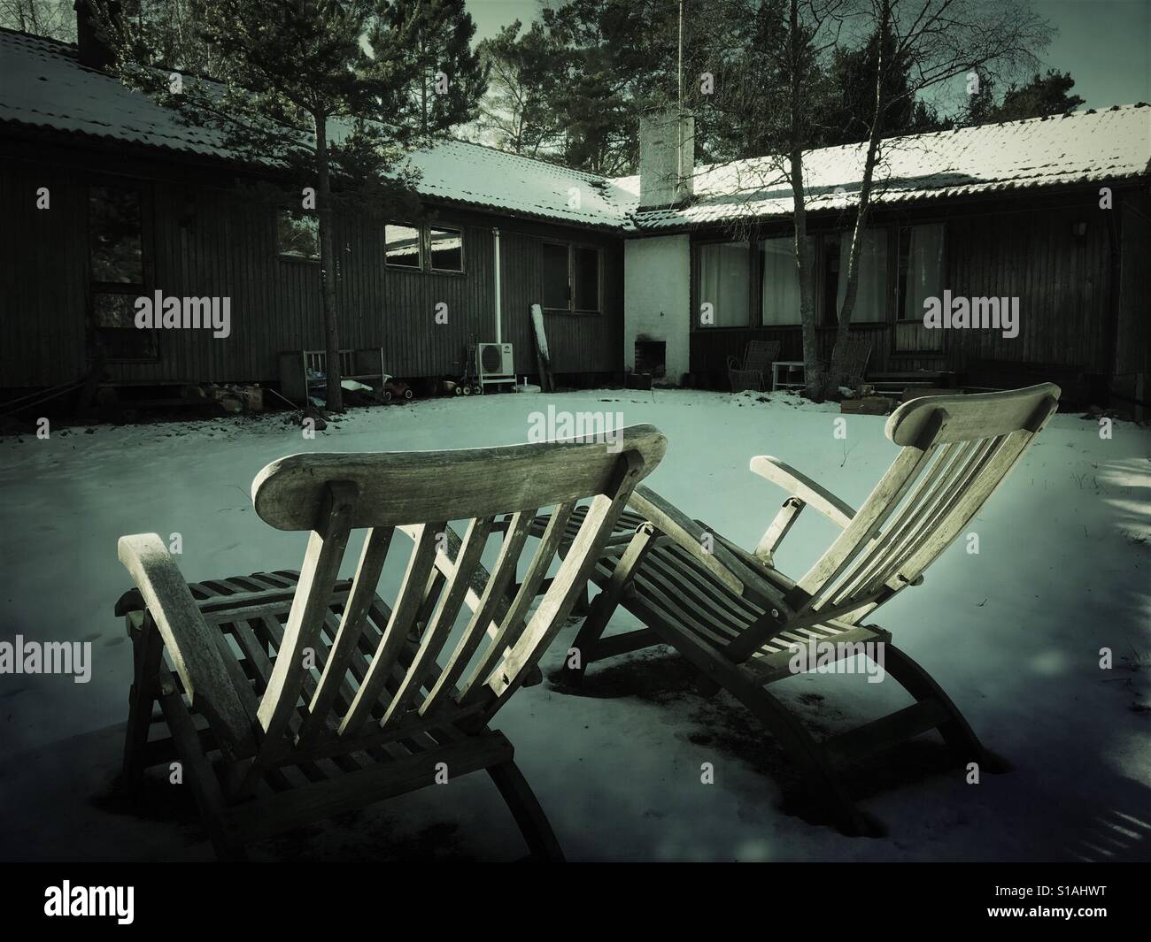 2 relax lounger chairs outside Swedish summer house in winter - Smartphone Captured Stock Image