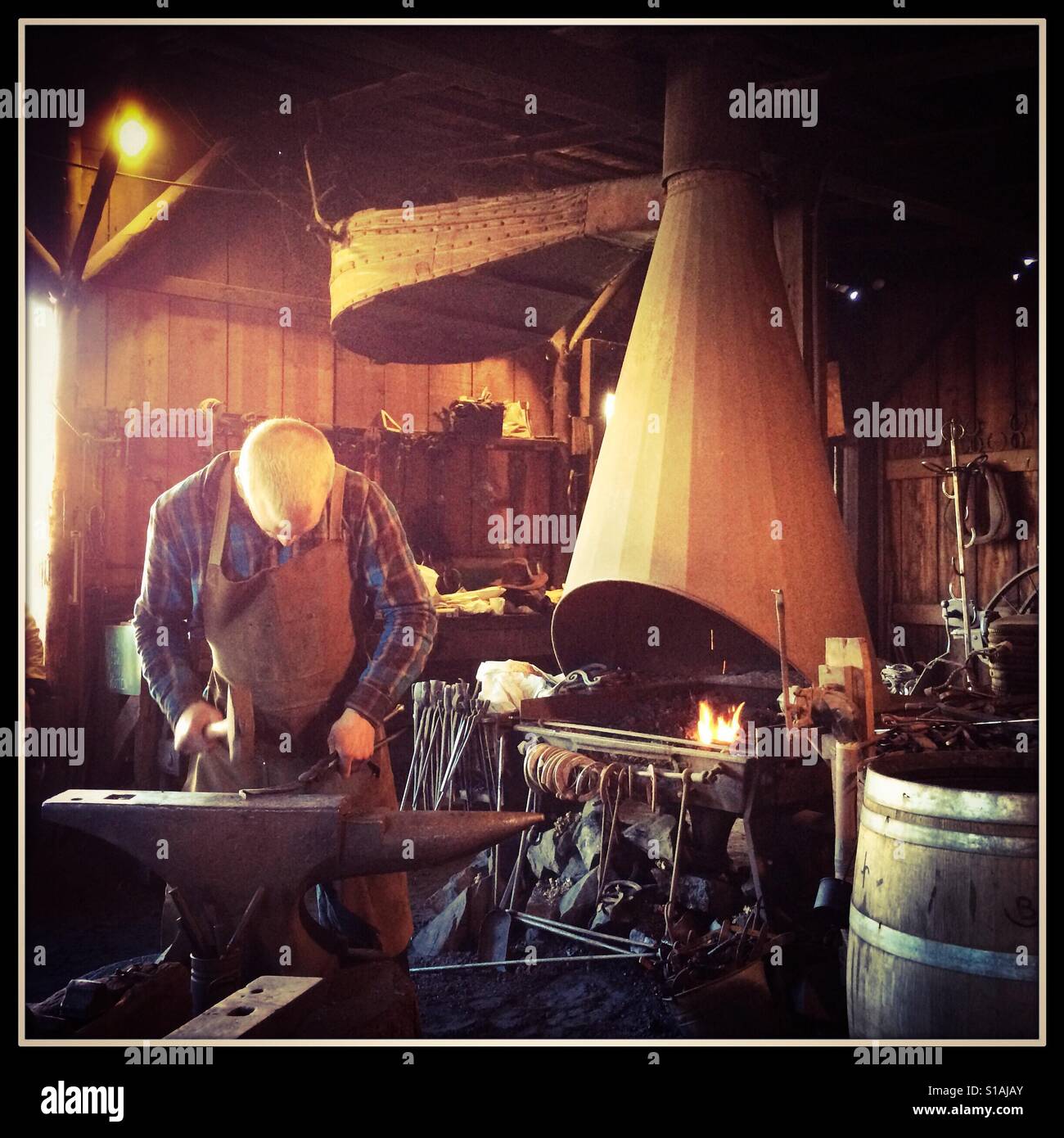 A blacksmith works in his workshop on Main Street. Columbia State Historic Park, Columbia, Tuolumne County,  California, USA - Smartphone Captured Stock Image