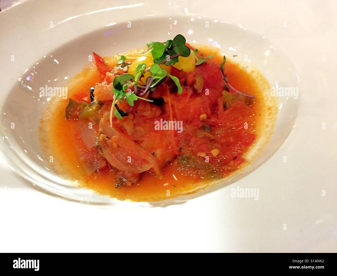 Baked red snapper topped with Veracruzana  sauce and served  with tomato rice served at luxury upscale restaurant,  NYC,  USA - Smartphone Captured Stock Image