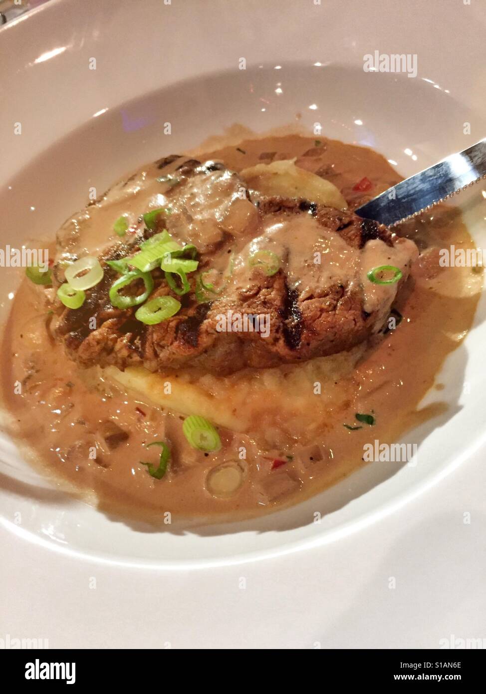 Fillet mignon steak topped with a red wine mushroom cream sauce and served with mashed potatoes in upscale luxury restaurant, NYC, USA Stock Photo