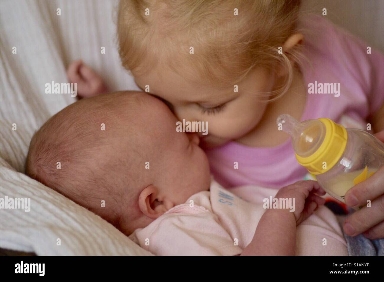 https://c8.alamy.com/comp/S1ANYP/little-girl-kisses-baby-sister-while-feeding-bottle-S1ANYP.jpg