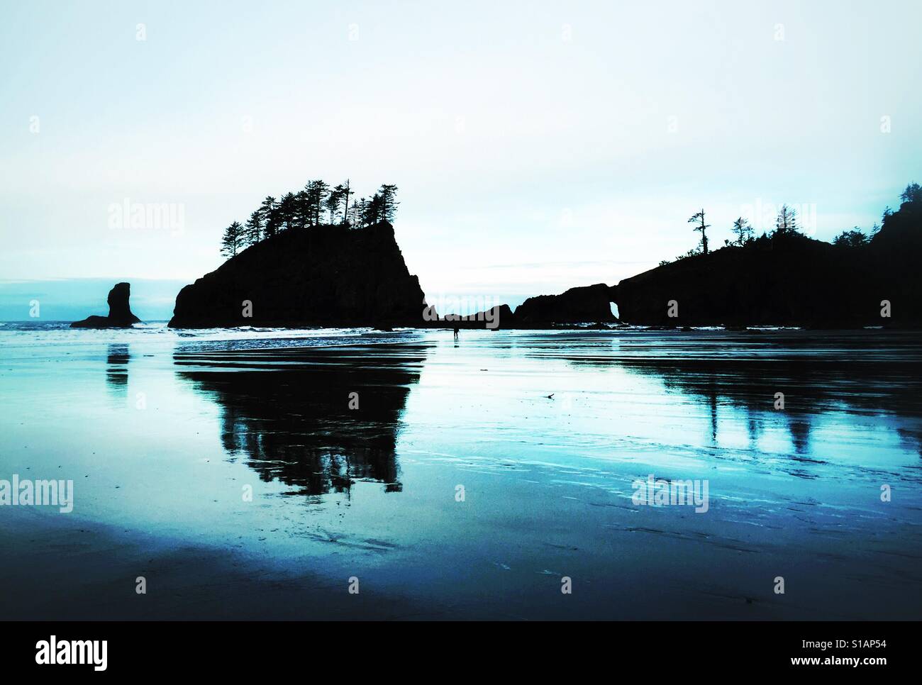 The largest of the Quillayute Needles, a seastack called Crying Lady Rock stands guard near a natural arch, at Second Beach in Olympic National Park, Washington. - Smartphone Captured Stock Image