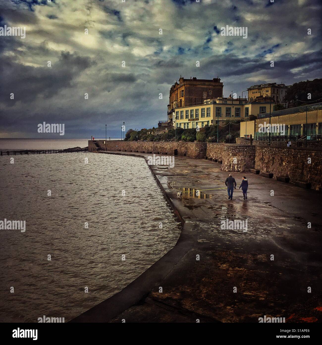 A couple walking on the walkway around the Marine Lake in Weston super Mare, North Somerset, England - Smartphone Captured Stock Image