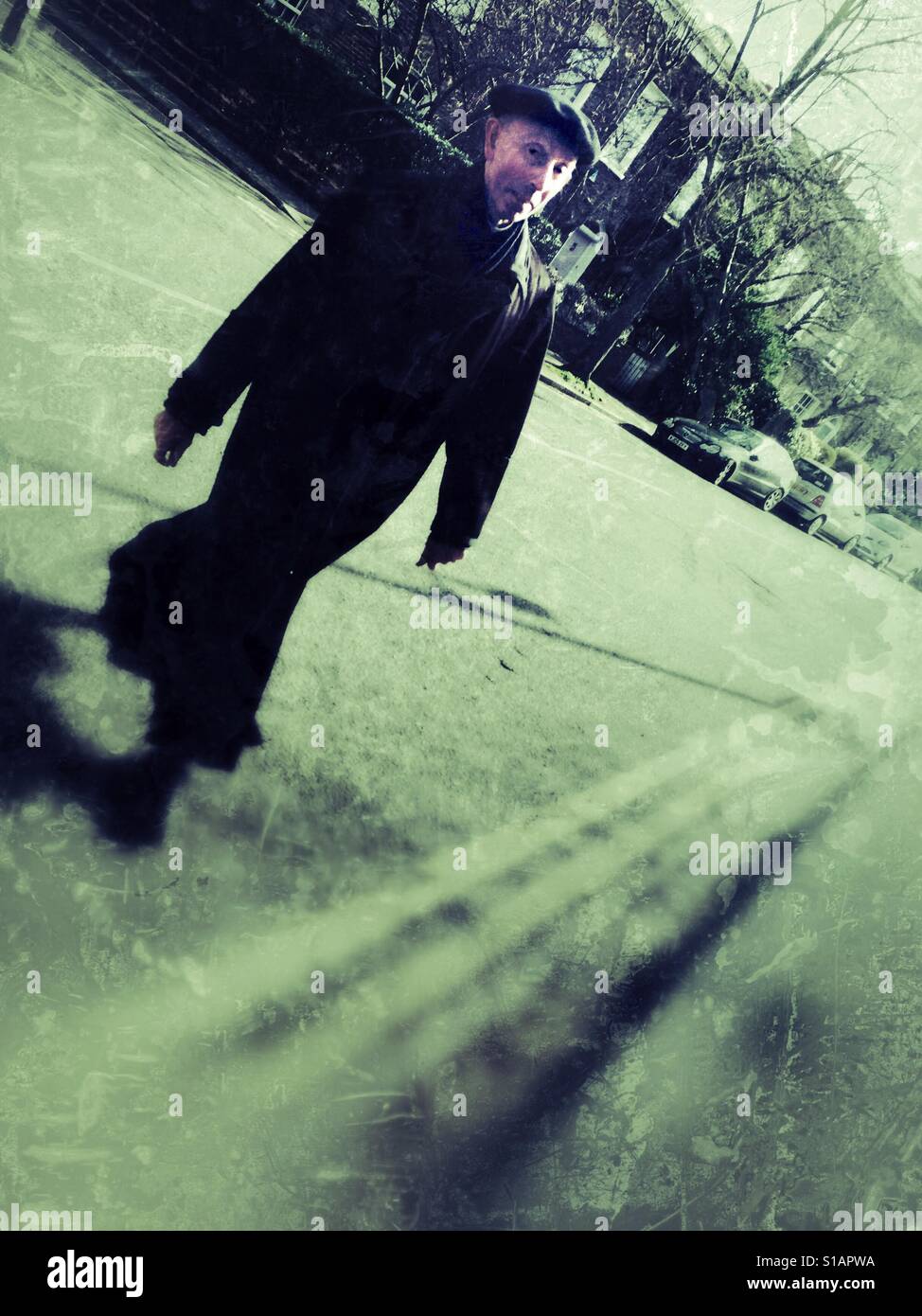 Man in a long black coat crossing the road - Smartphone Captured Stock Image