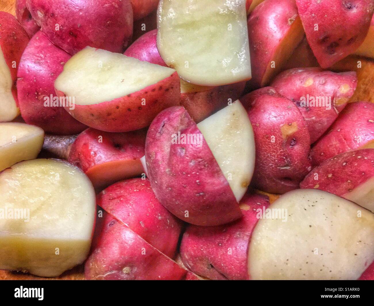 Red potato pieces cut up into quarters Stock Photo Alamy