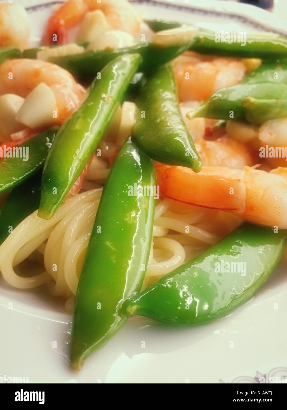 Shrimp and snap pea pasta dish with spaghetti, USA - Smartphone Captured Stock Image