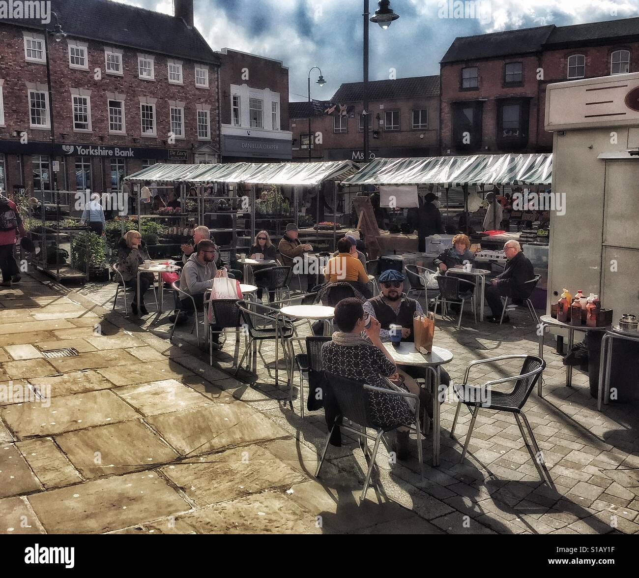 People sitting in an open air cafe in the market town of Beverley in the East Riding of Yorkshire - Smartphone Captured Stock Image