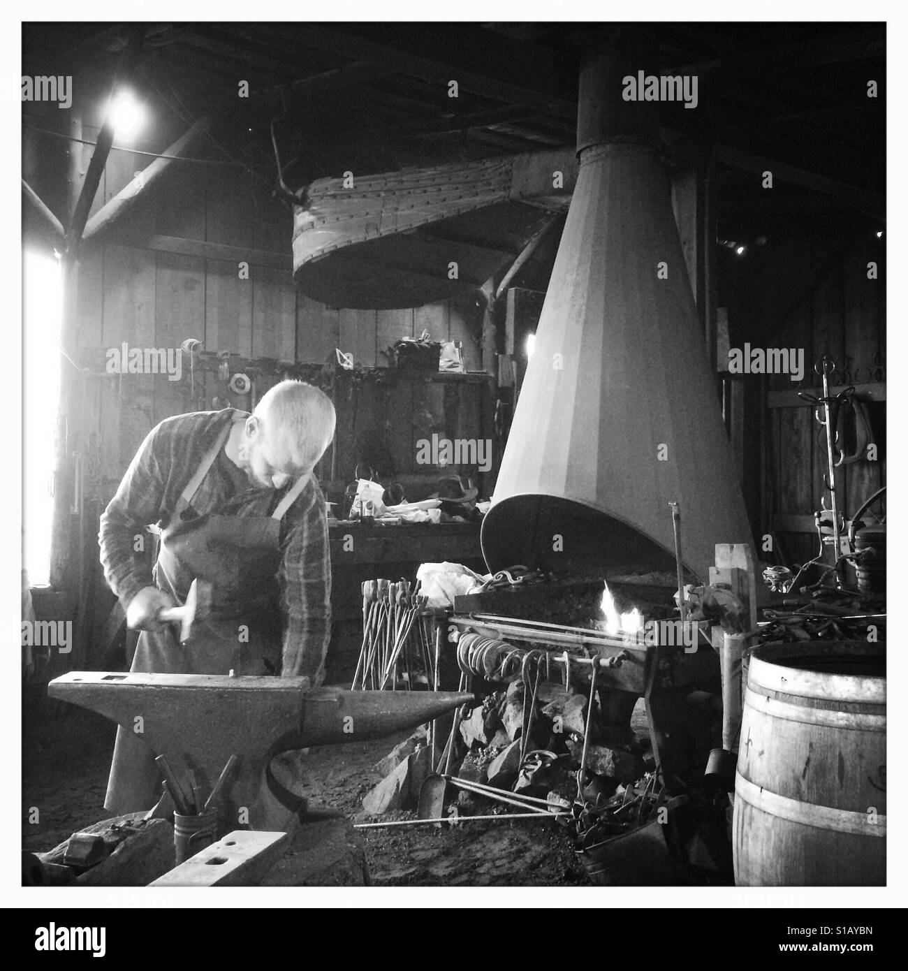 A blacksmith works in his workshop on Main Street. Columbia State Historic Park, Columbia, Tuolumne County,  California, USA - Smartphone Captured Stock Image