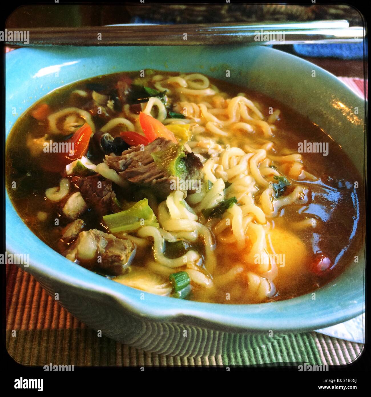 A bowl of homemade spicy beef ramen soup. - Smartphone Captured Stock Image