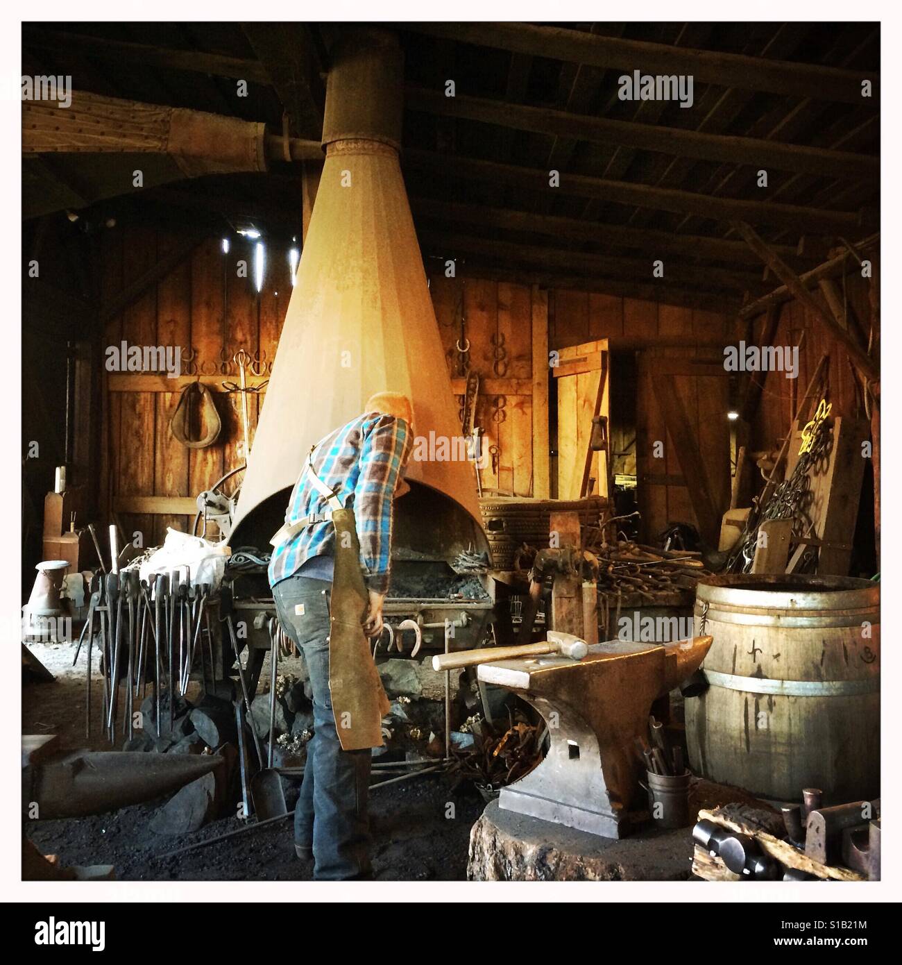 A blacksmith works in his workshop on Main Street. Columbia State Historic Park, Columbia, Tuolumne County,  California, USA - Smartphone Captured Stock Image