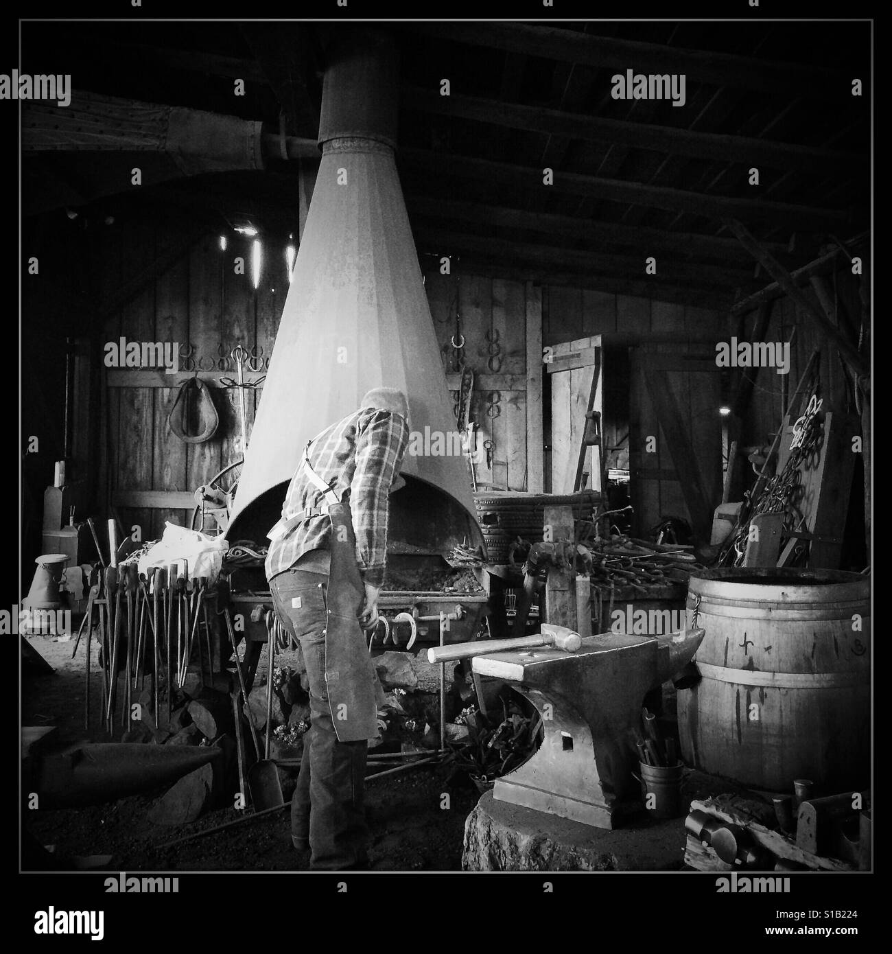 A blacksmith works in his workshop on Main Street. Columbia State Historic Park, Columbia, Tuolumne County,  California, USA - Smartphone Captured Stock Image
