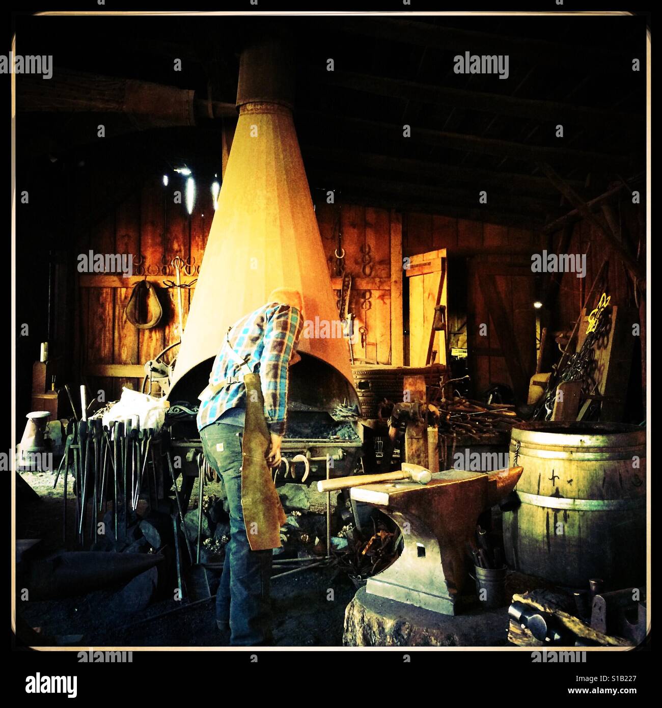 A blacksmith works in his workshop on Main Street. Columbia State Historic Park, Columbia, Tuolumne County,  California, USA - Smartphone Captured Stock Image