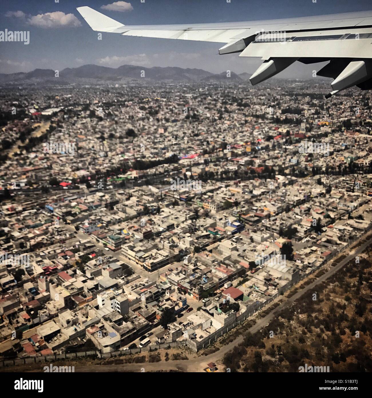 A plane flies over Mexico City, Mexico Stock Photo
