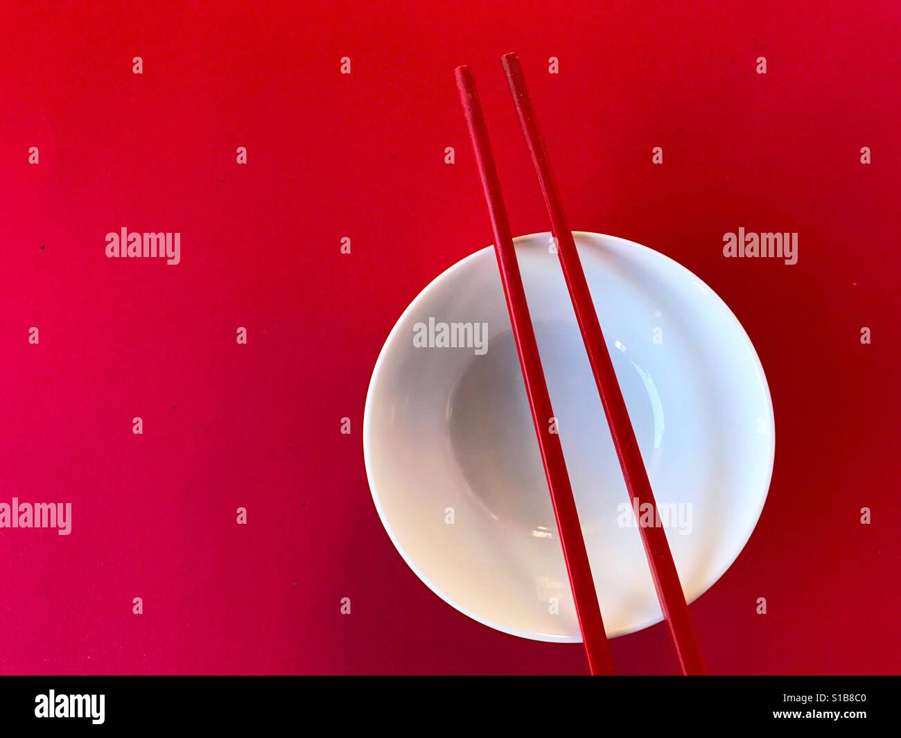 White bowl with chopsticks on red - Smartphone Captured Stock Image