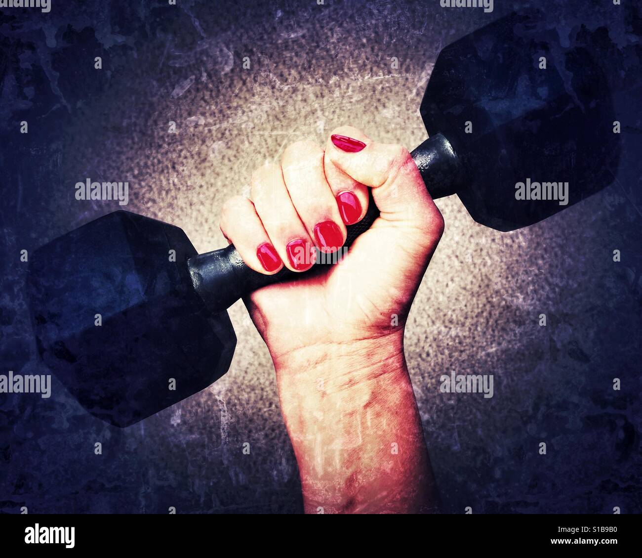 Woman's manicured hand holding a dumbbell weight. Grunge edit. Stock Photo