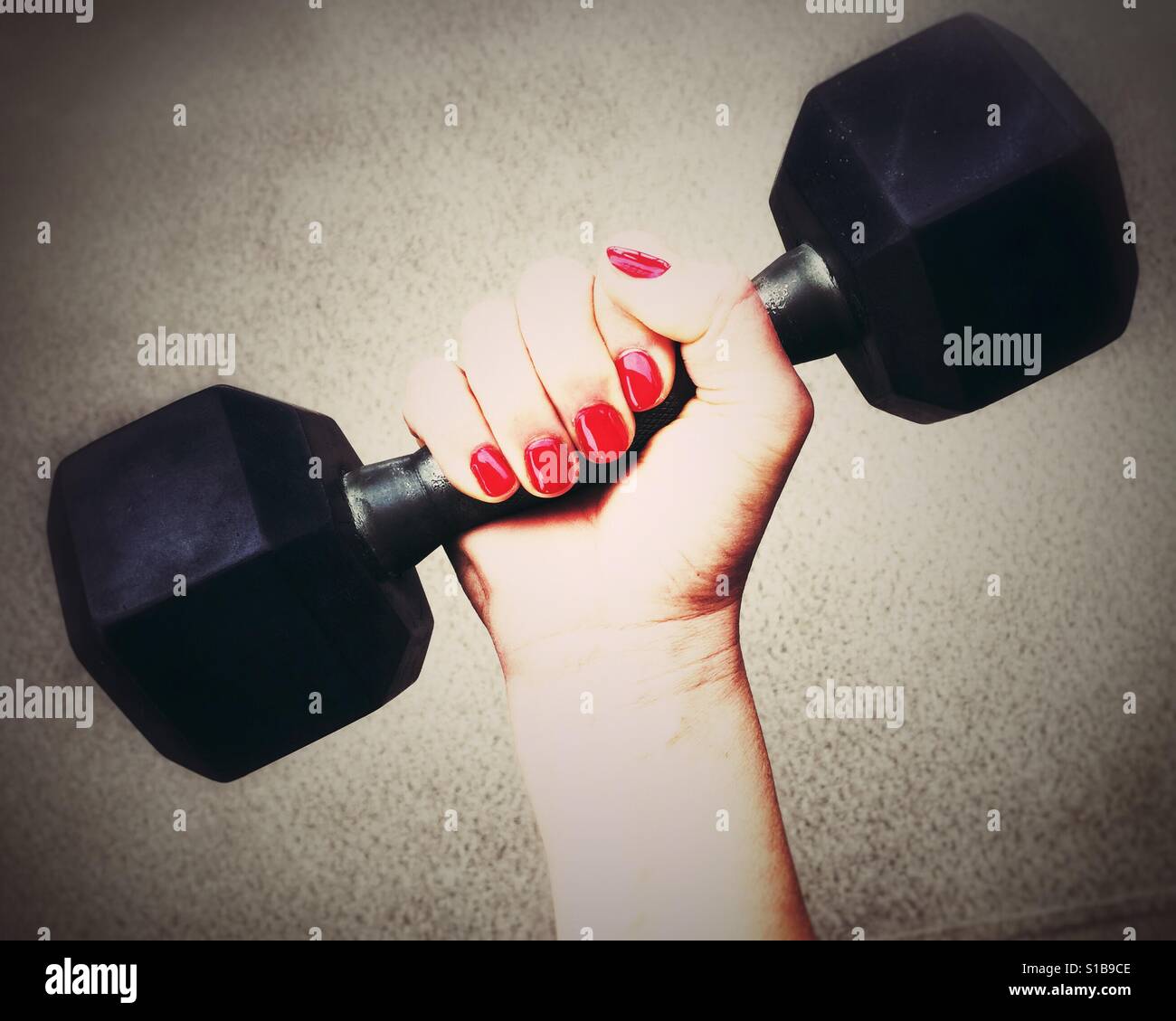 Close up of a woman's hand gripping a dumbbell. - Smartphone Captured Stock Image