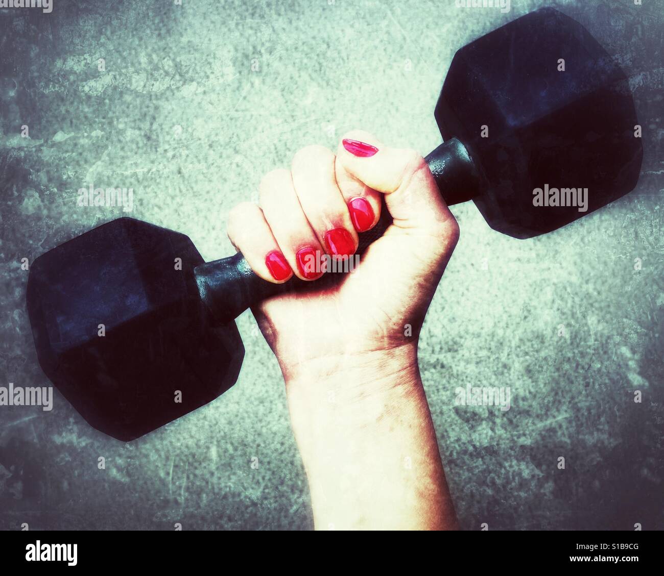 Close up of a woman's hand holding onto a dumbbell. - Smartphone Captured Stock Image