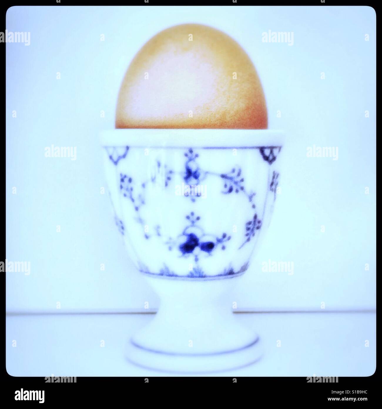 Boiled egg in decorative egg cup Stock Photo