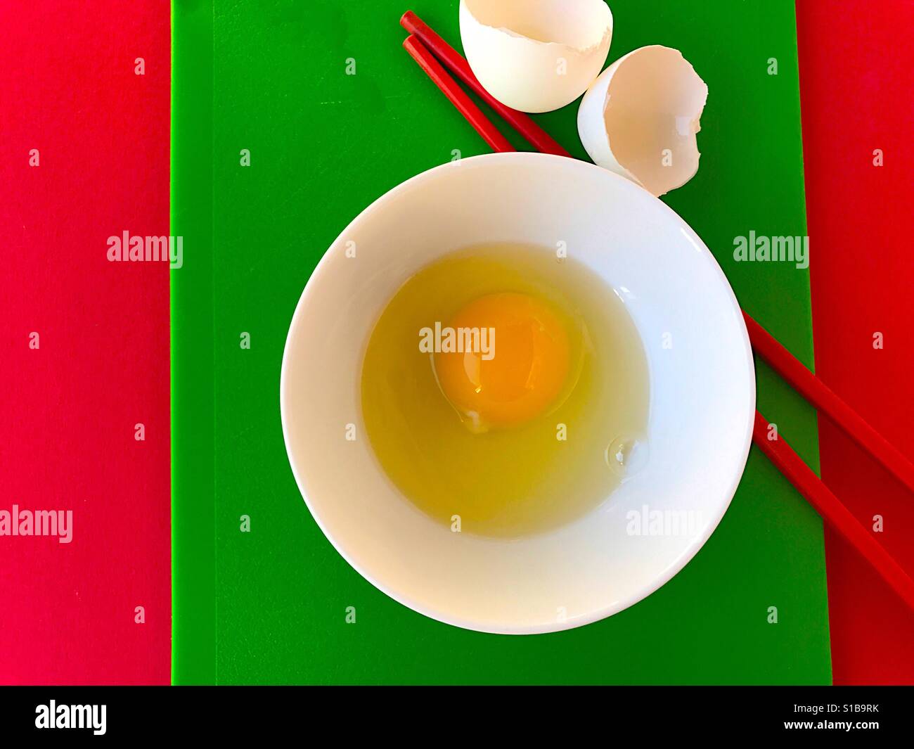 Bowl with raw egg in red and green - Smartphone Captured Stock Image