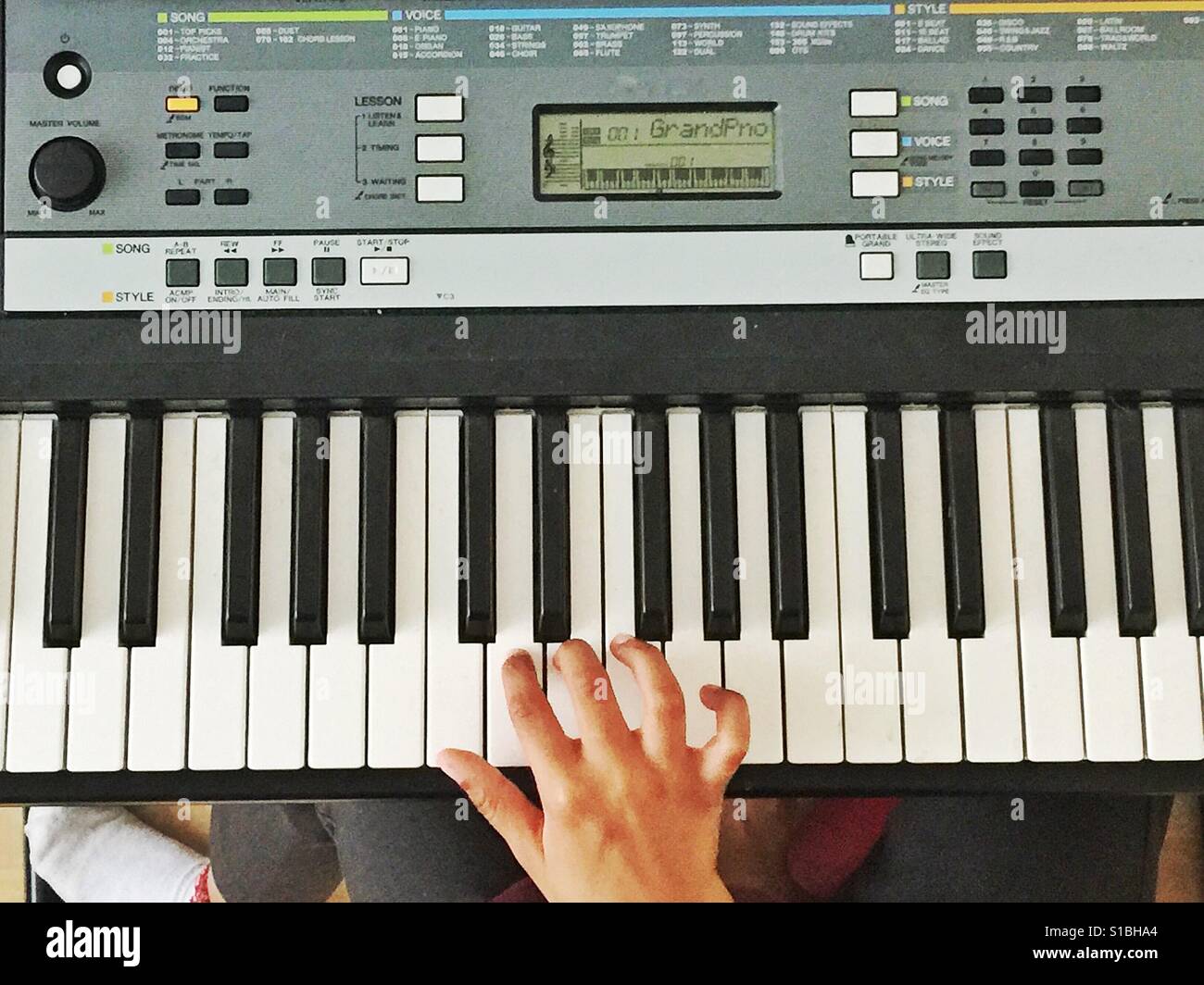 A child's hand playing a keyboard. Stock Photo